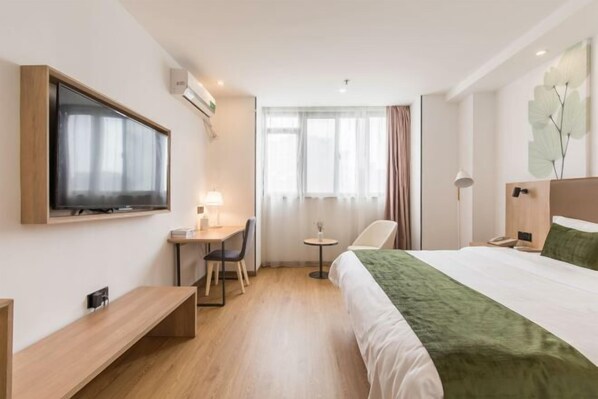 A hotel room with a bed, desk, chair, TV, and a small table. - GreenTree Inn (Shanghai Zhoupu Xiupu Road Kangqiao Metro Station) (Shanghai)
