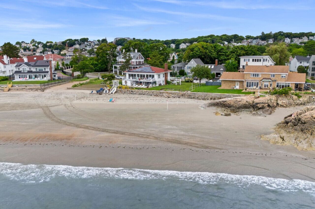 A coastal beach area with houses and a sandy beach.