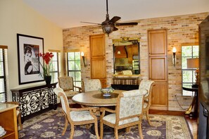 A dining area with a brick wall, wooden cabinets, and a ceiling fan. - Phillips Creek Villa in South Fort Myers (Fort Myers)