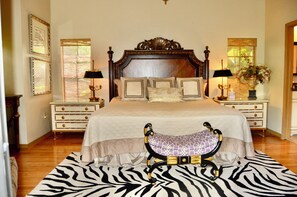 A bedroom with a large bed, two nightstands, a zebra-patterned rug, and a chaise lounge. - Phillips Creek Villa in South Fort Myers (Fort Myers)