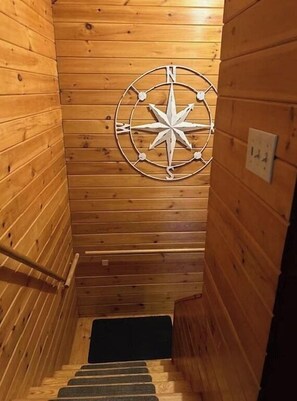 Stunning spiral staircase leads to an upper level, featuring a large compass above.