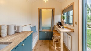 A compact kitchen with a wooden countertop, a sink, and a window overlooking a garden. - Set among the fruit trees with views of the fields. (Ongar)