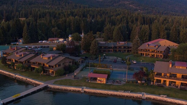 A lakeside resort with multiple buildings, a dock, and a small boat. - Lakefront - 3 Bedroom (Hope)