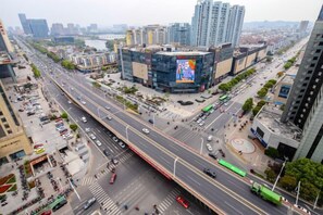 A multi-level urban street with a prominent building featuring a large billboard. - Kaiweina Hotel (Shengtai Road Subway Station Store) (Nanjing)