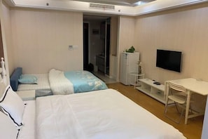 A hotel room with two beds, a TV, a desk, and a wardrobe. - Kaiweina Hotel (Shengtai Road Subway Station Store) (Nanjing)