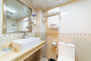 Ein Badezimmer mit Waschbecken, Spiegel, Handtuchhalter und Toilette.