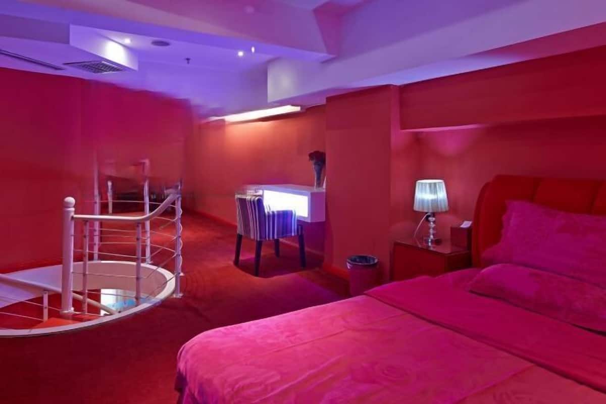 Una habitación con cama, escritorio, silla y una pequeña mesa.