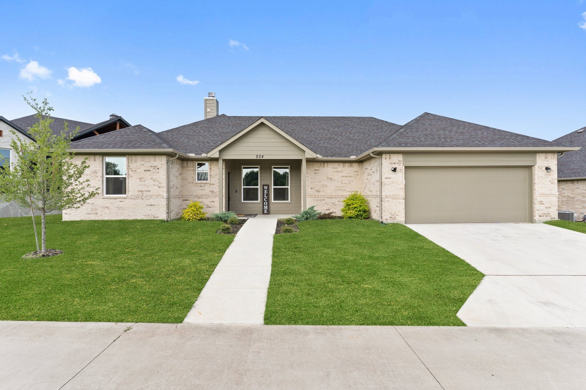A single-story house with a beige exterior, a front garage, and a well-maintained lawn.
