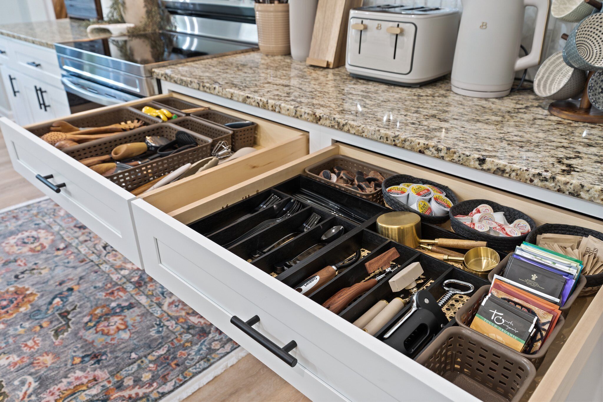 Una cocina con un organizador de cajones que contiene utensilios, una cafetera y un tostador.