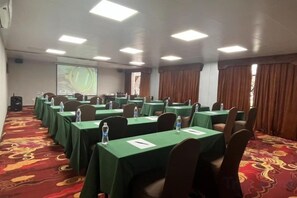 A conference room with tables, chairs, and a projector screen. - Lakeside Garden Wudelou Hotel (Wuhan)