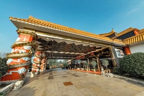 A traditional Chinese architectural entrance with ornate pillars and a tiled roof.