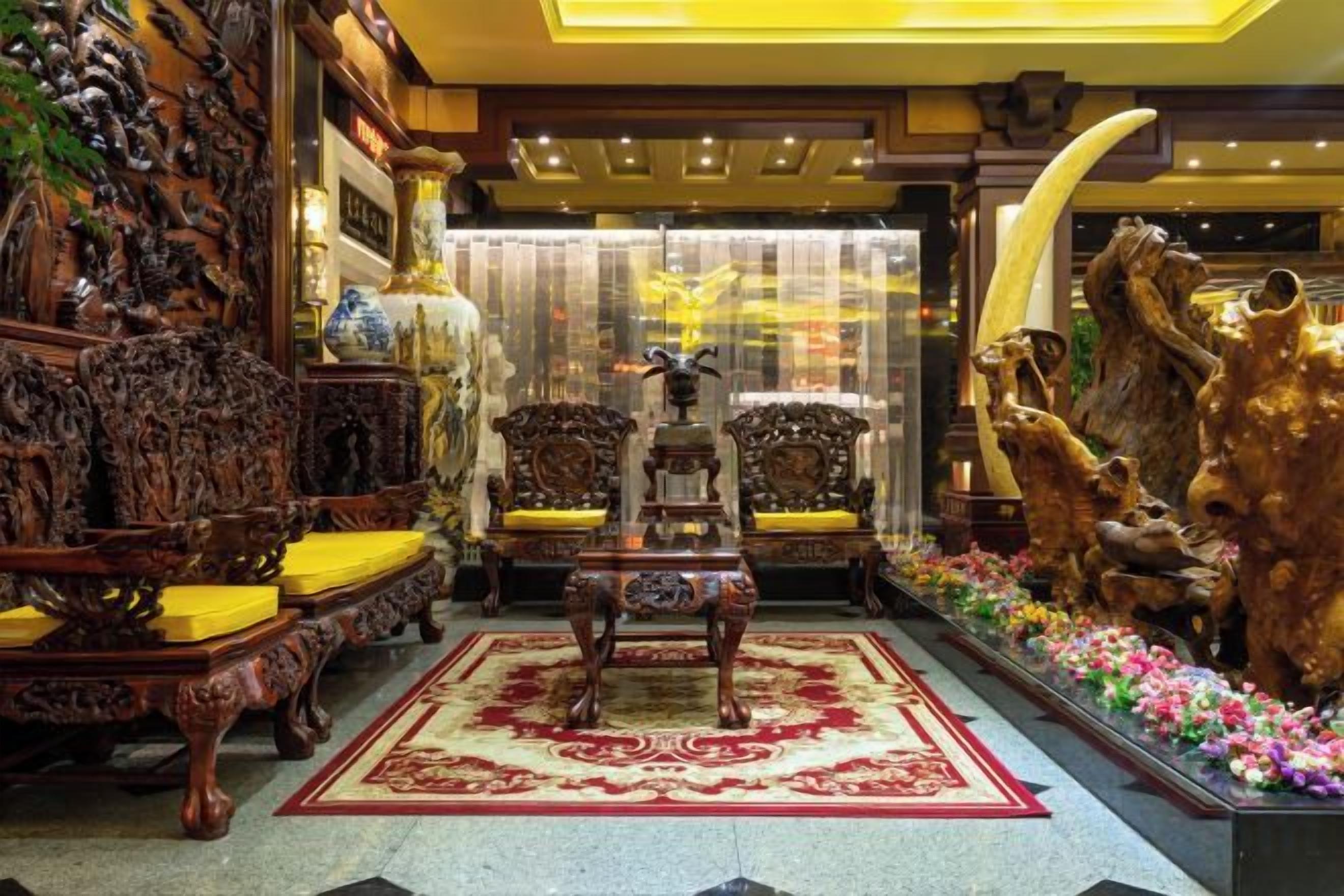 An ornate lobby with traditional furniture, a central fountain, and decorative animal sculptures.