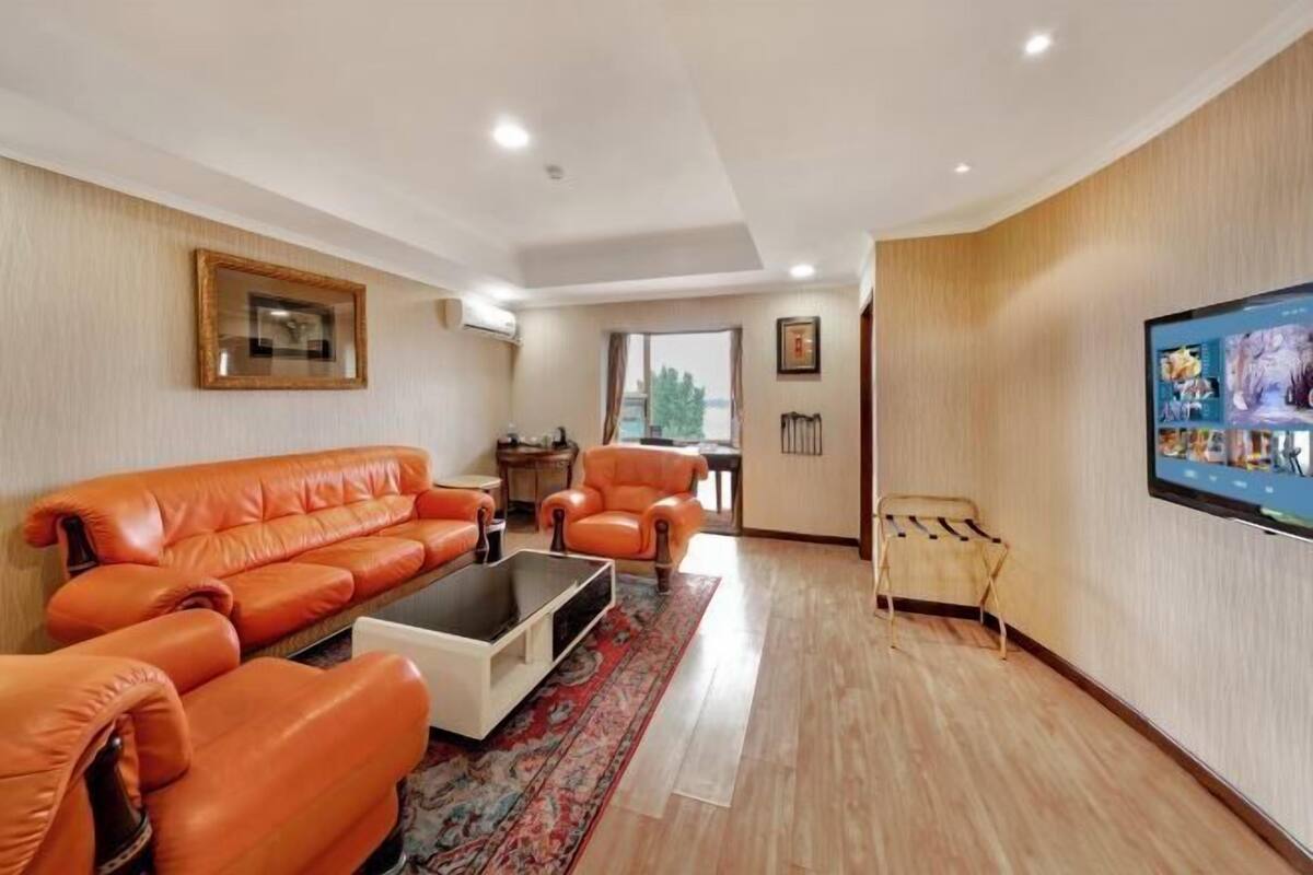 A living room with a sofa, armchairs, a coffee table, and a TV.