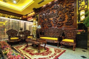 Um interior tradicional com móveis de madeira elaborados, um painel decorativo grande e piso coberto de carpete.