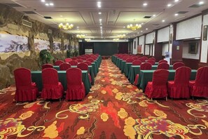 A conference room with rows of tables and chairs, a patterned carpet, and a mural on the wall. - Lakeside Garden Wudelou Hotel (Wuhan)