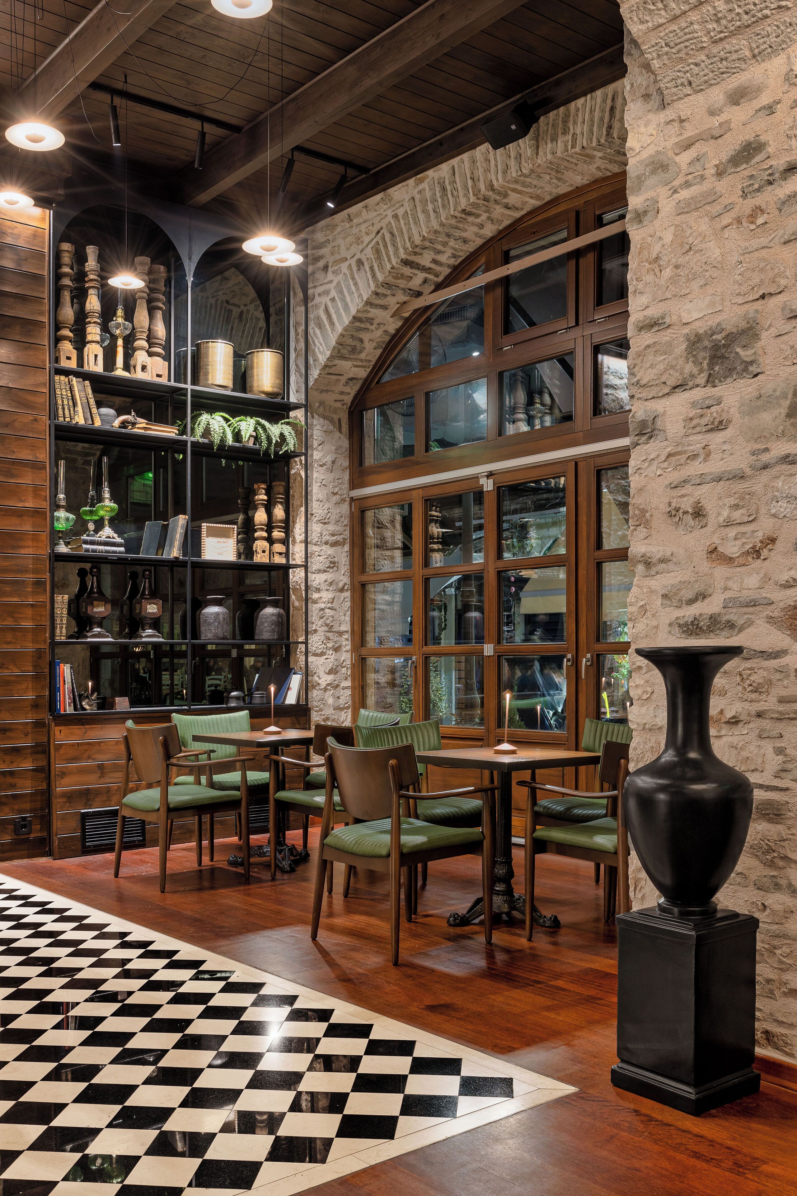 A cozy room with wooden shelves, a checkered floor, and a large window with a view.
