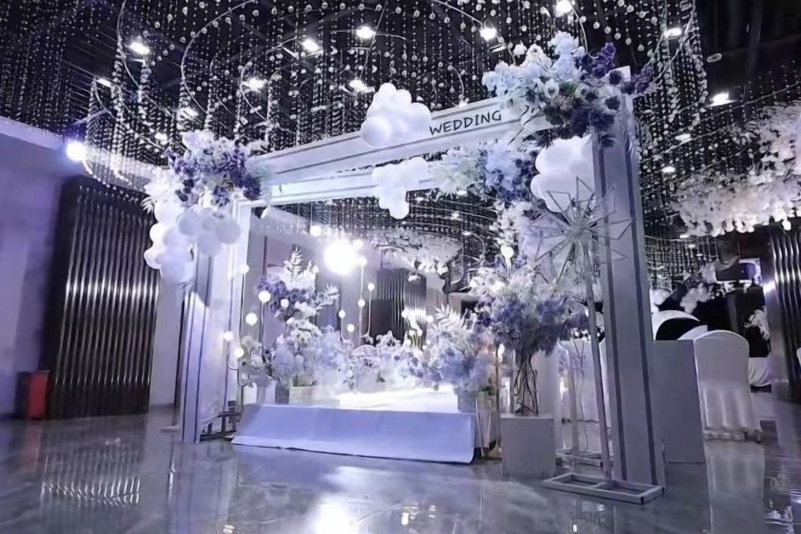 Un arco de bodas con adornos florales y un letrero que dice 'WEDDING'.