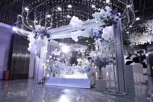 Un arco de bodas con adornos florales y un letrero que dice 'WEDDING'.