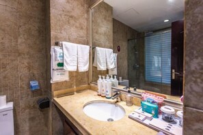 Un bagno con lavandino, specchio e articoli da toilette.
