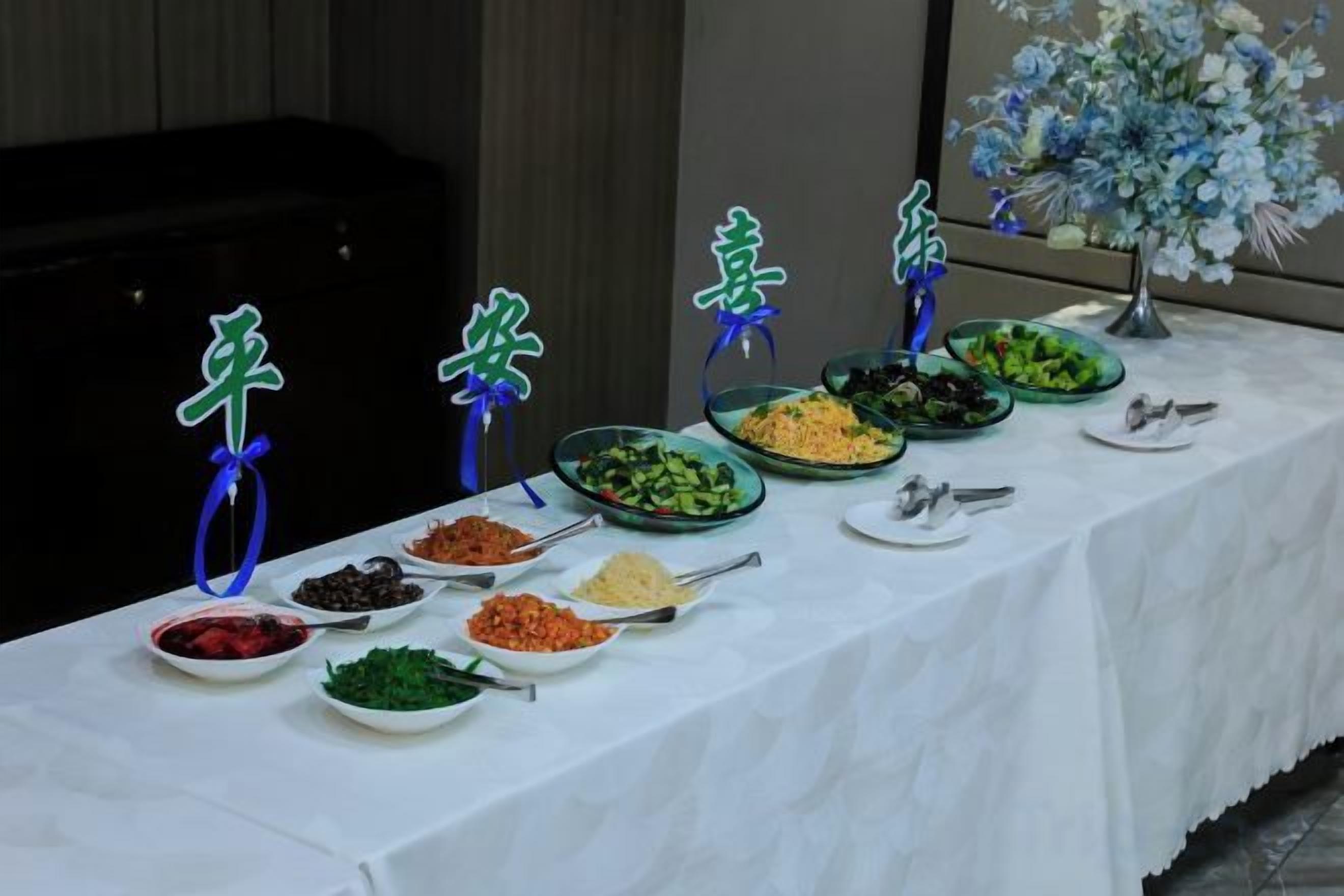 Una mesa de buffet con diversos platos y una decoración floral.