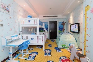 Una stanza giochi per bambini con un letto a castello, una scrivania da gioco e una tenda.