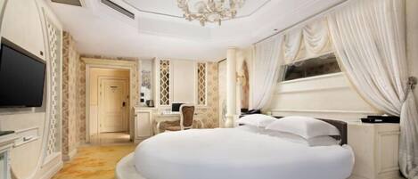 Une chambre à coucher luxueuse avec un lit rond, un lustre et une grande fenêtre avec des rideaux.