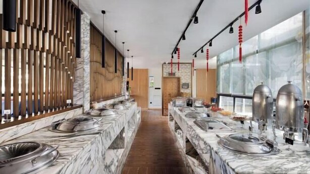 Uma cozinha moderna com bancadas de mármore, eletrodomésticos de aço inoxidável e um painel de ripas de madeira.