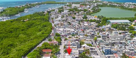 An aerial view of a coastal town with dense housing, a marina, and a large body of water.