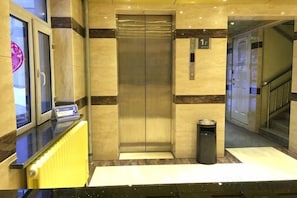 An elevator with a control panel, a trash bin, and a floor indicator. - Friendship City New Town Hotel (Youyi)