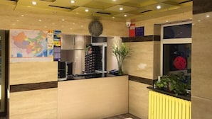 A reception area with a map, a clock, and a window with a red object. - Friendship City New Town Hotel (Youyi)