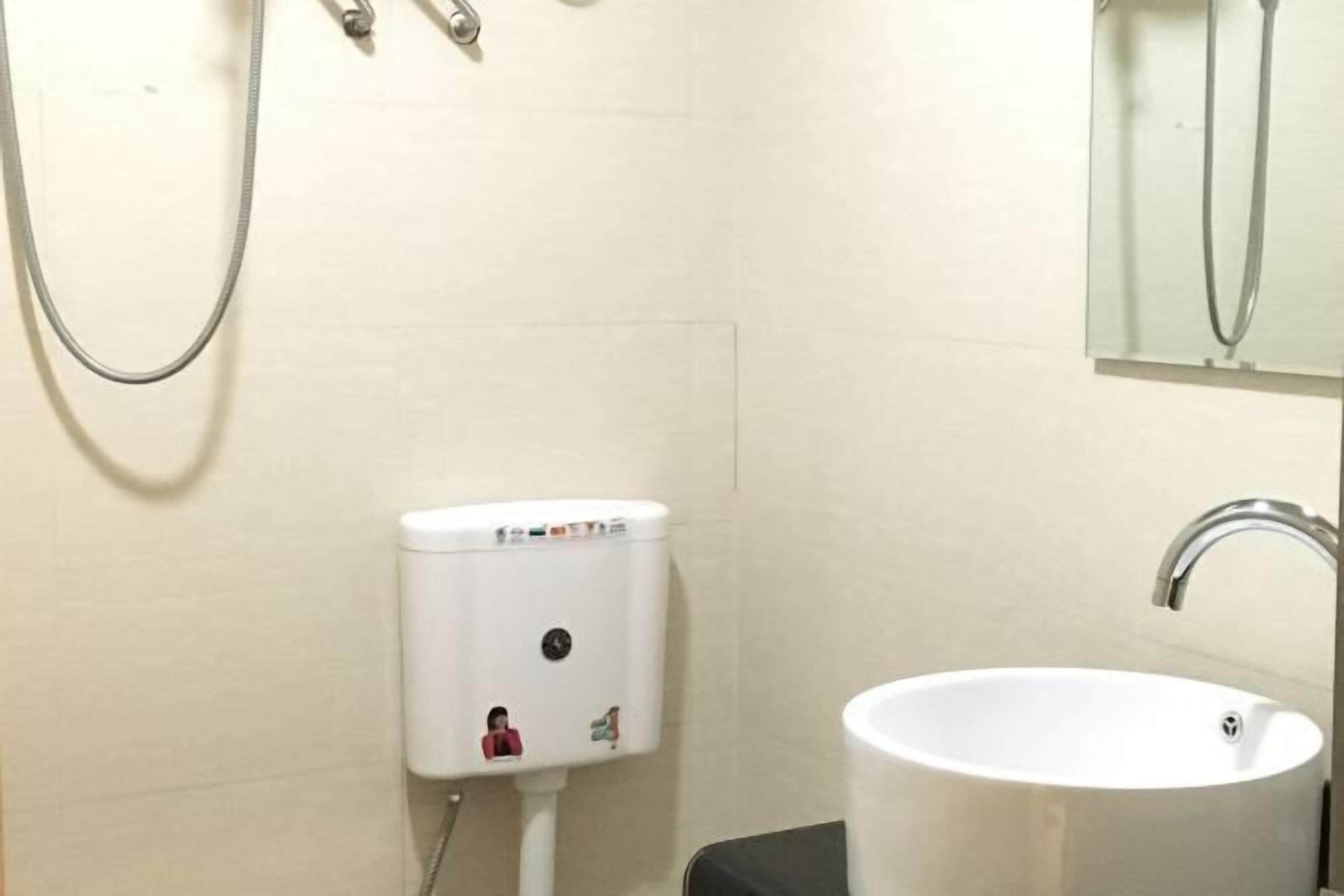 Un bany amb un lavabo blanc, un vàter i una dutxa.