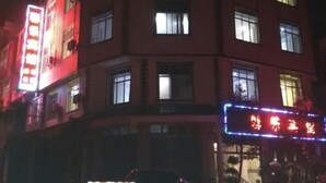 A multi-story building with illuminated signage, windows, and a visible entrance. - Citadel Luoping (Luoping)
