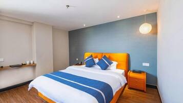 Una habitación de hotel moderna con una cama grande, una mesita de noche y una lámpara de pared.