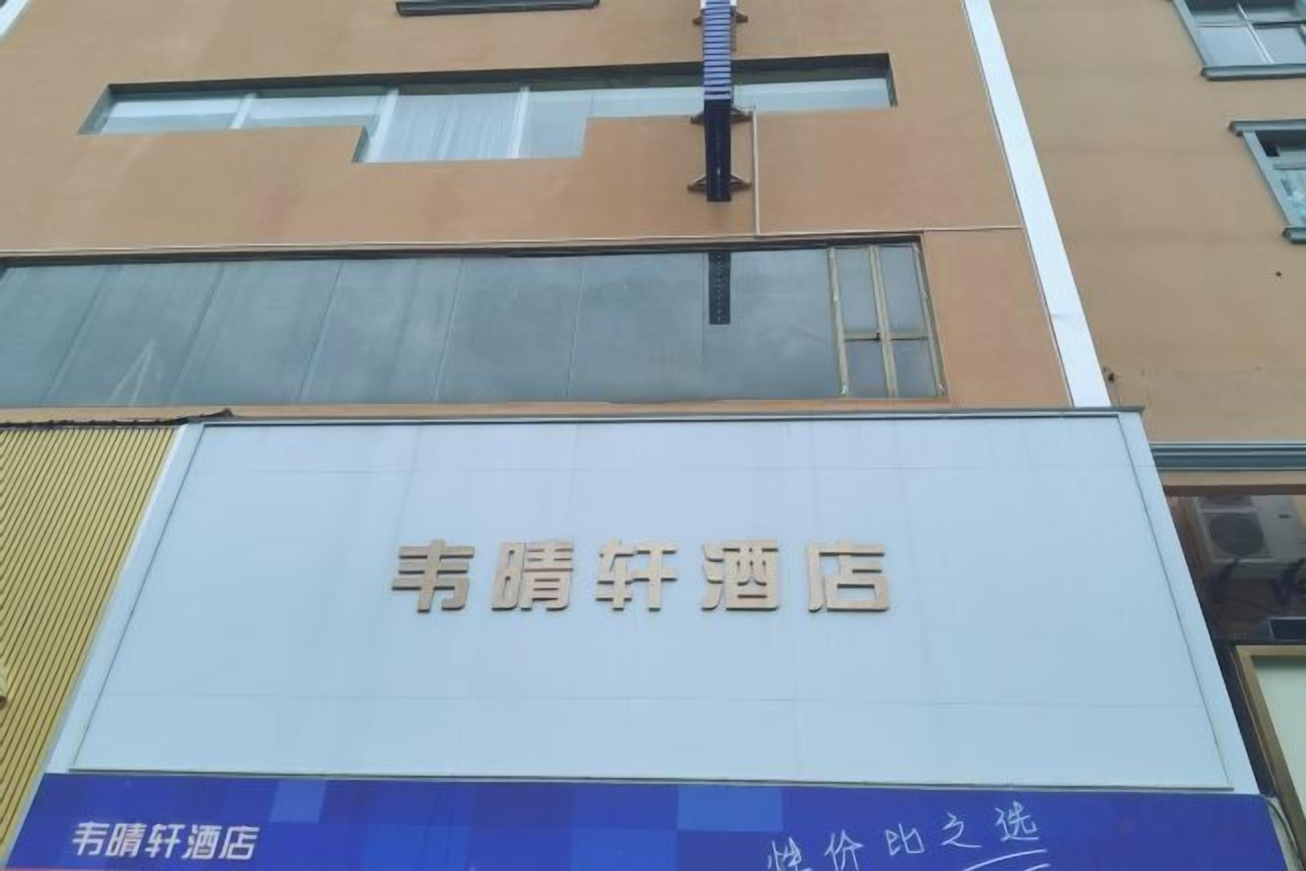 Placa de hotel com o nome '韵辉酒店' em letras douradas sobre fundo branco.