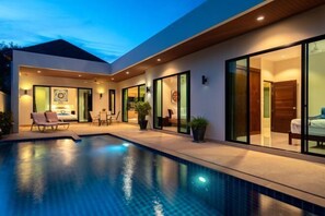 A modern house with a swimming pool, large sliding glass doors, and a well-lit interior. - Andaman 3Br Pool Villa （IV2V7） (Phuket)