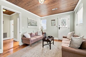 A living room with a wooden ceiling, two sofas, a coffee table, and a rug. - Historic Carriage House in Downtown 
119 S. Marshall St. Winston-Salem, NC 27101 (Winston-Salem)