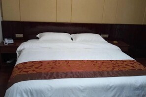 Ein Hotelzimmer mit einem Bett, einem Nachttisch und einem Telefon.