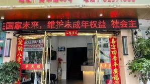A hotel entrance with a prominent sign displaying the address and phone number. - Minfeng Hotel (Yueqing)