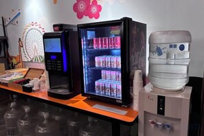 A vending machine with a digital display, a refrigerated beverage dispenser, and a water cooler. - Newful Hotel (Taipei)