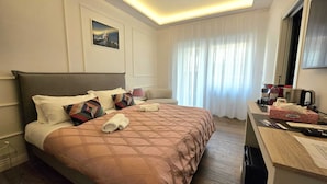 A hotel room with a bed, a desk with a computer, a telephone, and a window with curtains. - Riviera Suites Stanza 1 - by Be Your Home (Civitavecchia)