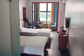 A hotel room with two beds, a small table, two chairs, a TV, and a window with curtains. - Quanjiao Jin'an Business Hotel (Quanjiao)
