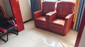 A room with a red leather sofa, a black and red office chair, and a tiled floor. - Quanjiao Jin'an Business Hotel (Quanjiao)