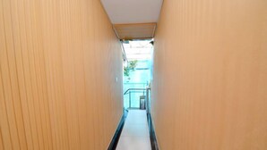 A narrow, tiled hallway with wooden walls and a metal railing at the end. - Quanjiao Jin'an Business Hotel (Quanjiao)