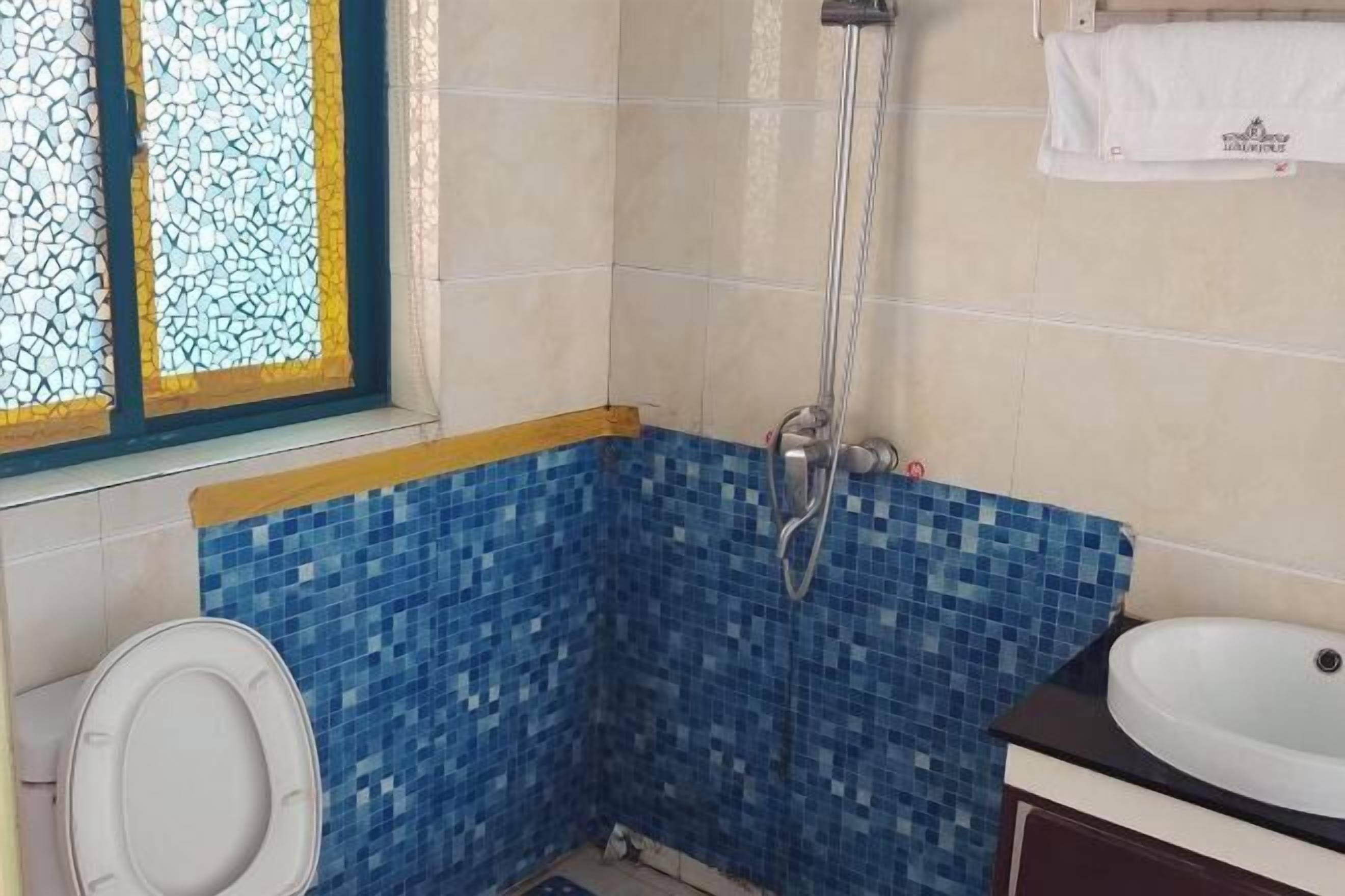 A bathroom with a shower, a toilet, and a sink.