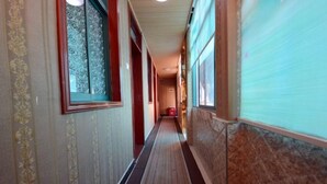 A corridor with patterned wallpaper, a carpeted floor, and a tiled wall. - Quanjiao Jin'an Business Hotel (Quanjiao)
