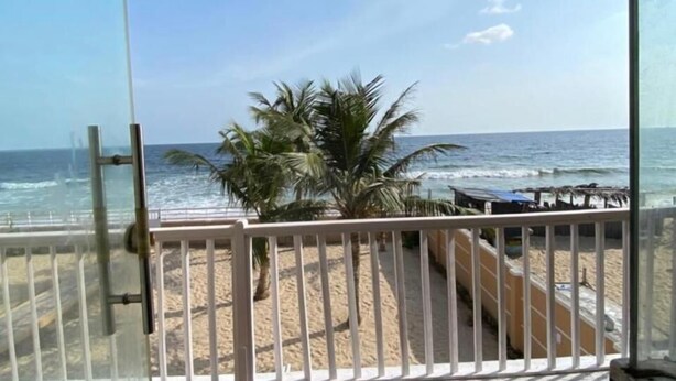 Un balcón con vista a la playa y al océano.