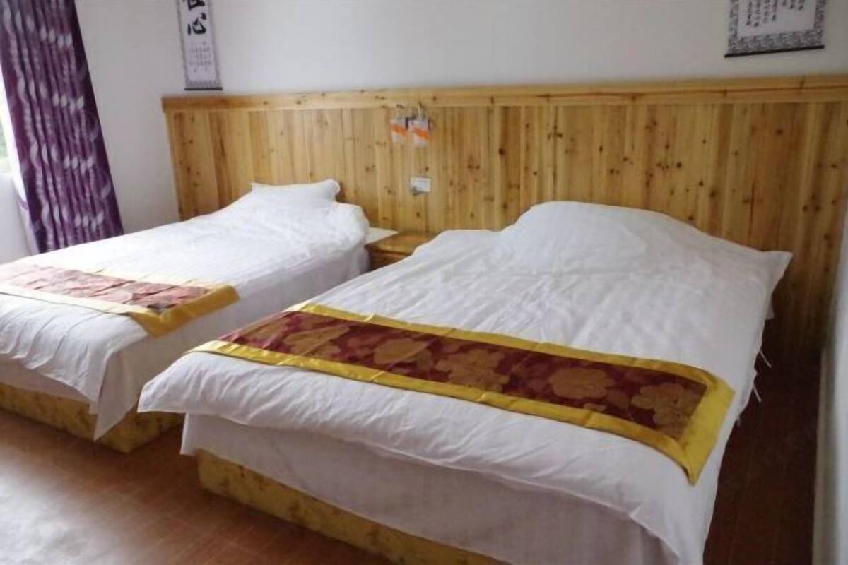 Two single beds with wooden headboards and white bedding.