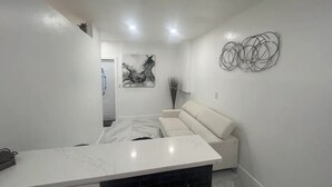 A modern kitchen with a marble countertop and a built-in black range hood. - Chic 1-bedroom apartment with AC, WiFi in fantastic Fort Myers (Fort Myers)