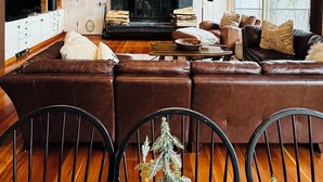 A cozy living room with a fireplace, wooden furniture, and a television. - Charming 4-bedroom Ski house in Stratton with Shuttle or walk to slope. (Stratton)