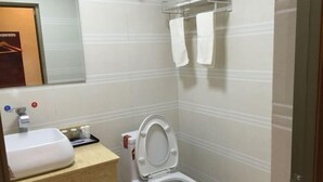 Un baño con inodoro, lavamanos y toallero blancos.